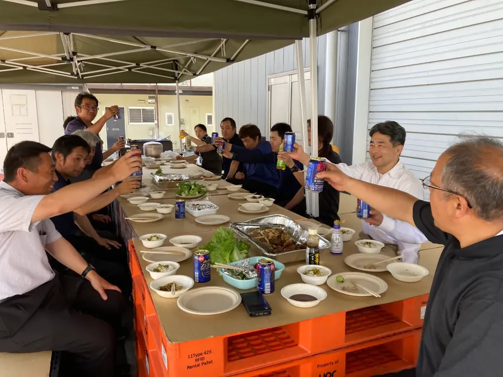 社内BBQで乾杯する社員