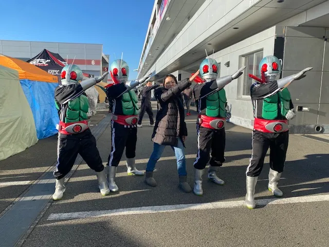 イベント会場でヒーローと記念撮影する社員