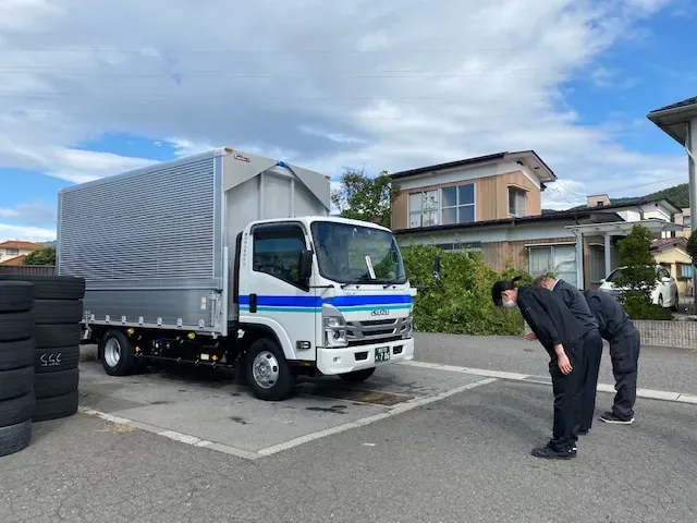 出発前のウイング車と点検するドライバー
